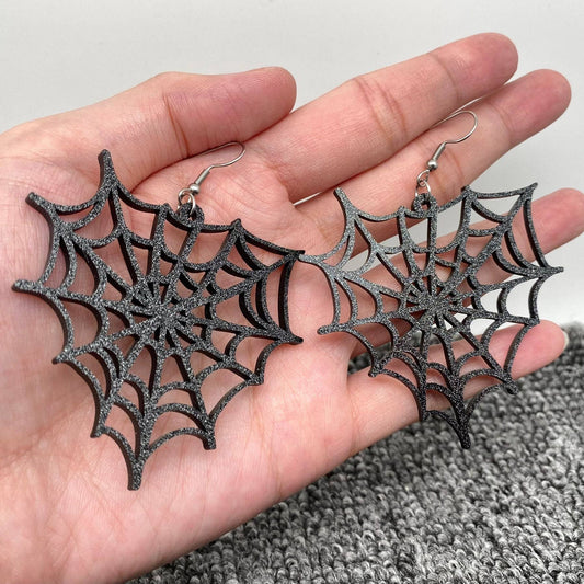 Hand Holding Black Glitter Spiderweb Earrings